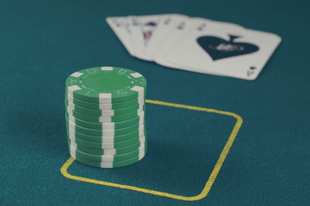 Poker chips on a table with cards behind them