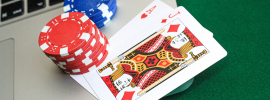 poker chips and playing cards sitting on a laptop